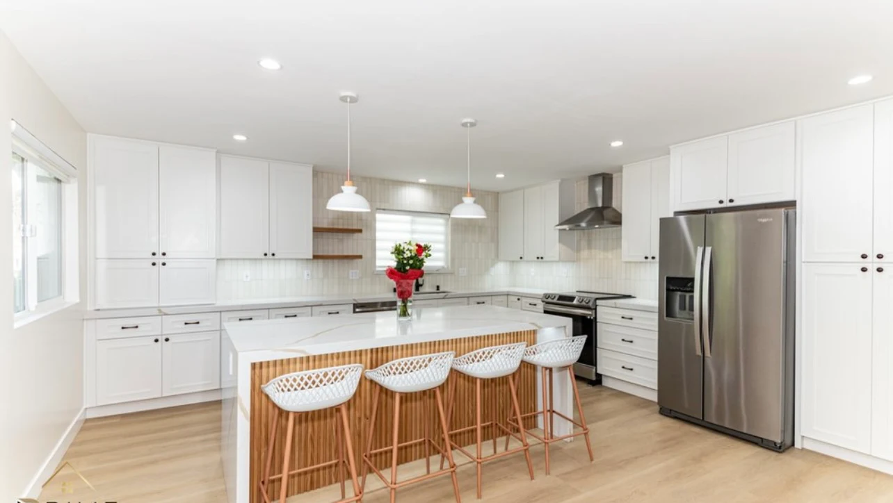 Bright white kitchen with wood island and pendant lighting — Simply Stunning Los Angeles